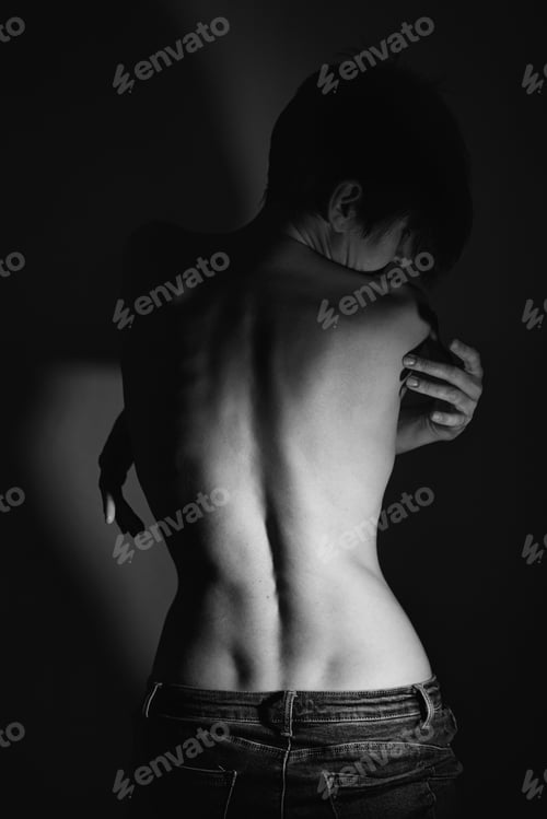 Preview: Topless calm female with folded arms standing near wall