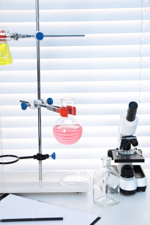 Preview: Laboratory analysis. Flasks with liquids and microscope on white table