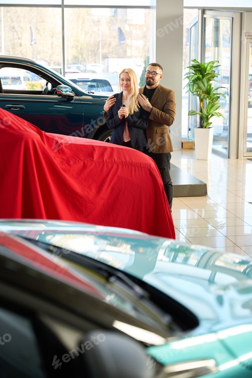 Visualização: Guy está ao lado de uma mulher em uma concessionária de carros