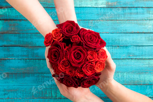 Preview: top view of hands holding roses bouquet