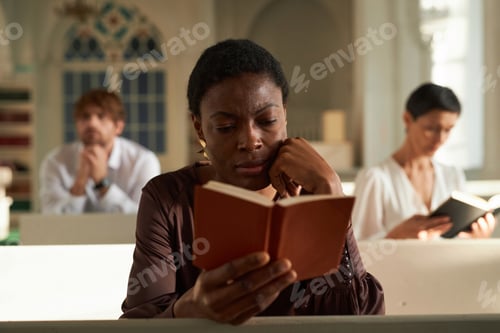 Preview: Adult African American Woman Reading Bible in Church on Sunday