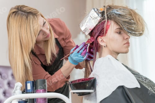 Preview: hairdresser makes hair coloring to young girl
