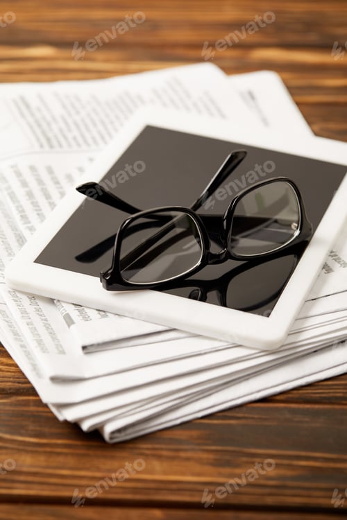 Preview: glasses, coffee cup, digital tablet and newsprint on wooden table