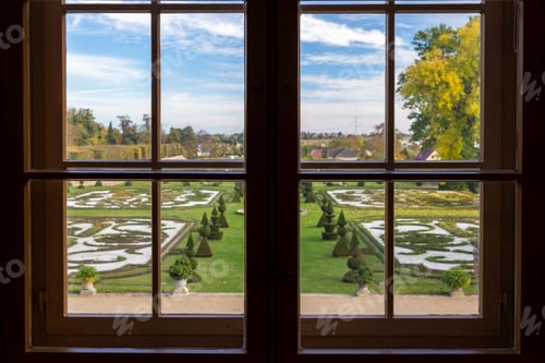 Preview: View through Hundisburg palace window reveals ornate garden sculpted hedges