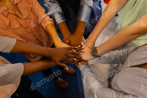 Preview: Holding hands of diverse casual businesswomen in office