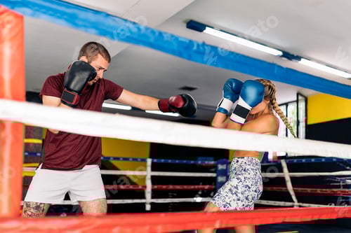 Preview: Young adult man and woman training box on the ring