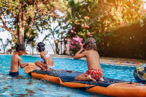 Preview: Relaxed children swim in pool together with boat in hotel