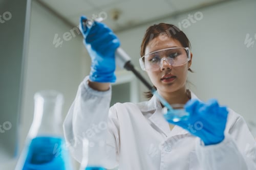 Preview: Female scientist pipetting liquid into petri dish