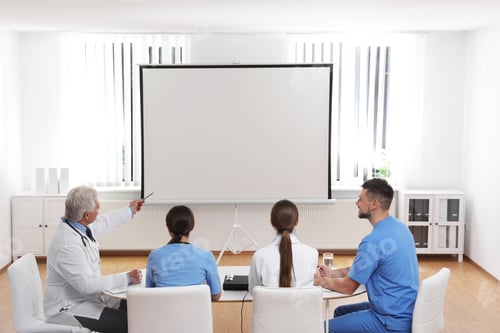 Preview: Team of doctors using video projector during conference indoors