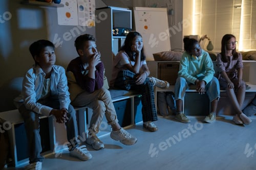 Preview: Multiracial schoolchildren sitting in classroom and watching video presentation