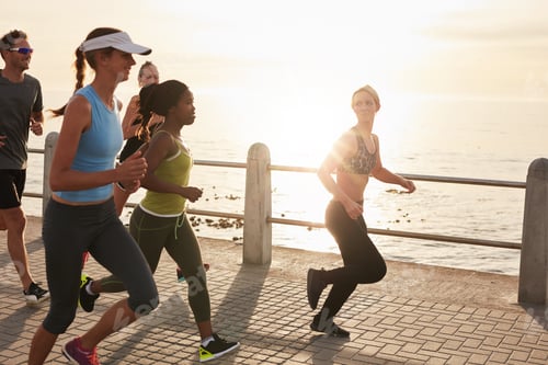 Preview: Young people running along seaside at sunset