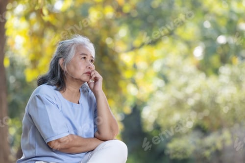 Preview: An elderly woman sits outdoors with a thoughtful expression