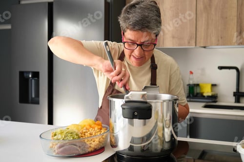 Preview: Mature Spanish woman cooking cocido, typical Spanish dish.