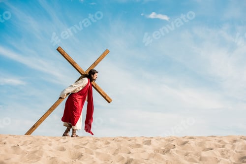 Preview: bearded man walking with wooden cross in desert