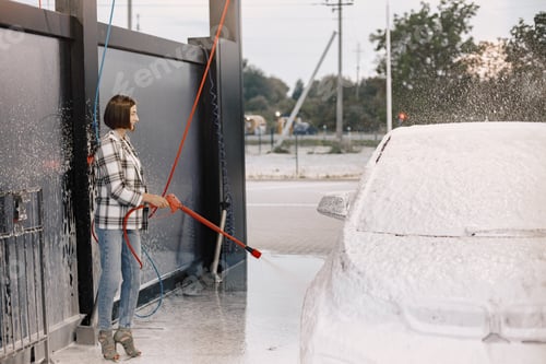 Preview: Woman washing her car in the car wash station