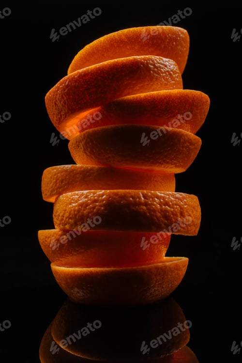 Preview: close-up shot of stacked slices of fresh orange isolated on black