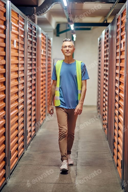 Preview: Man in special clothes walking through warehouse