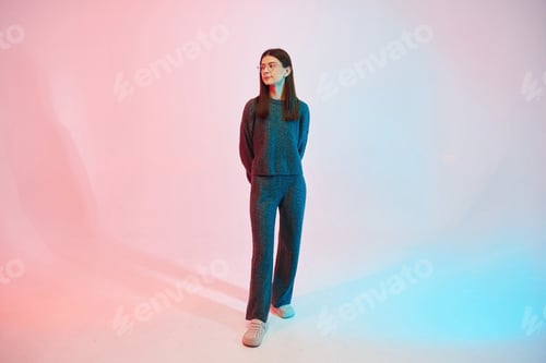 Preview: Young woman in glasses is standing in the studio