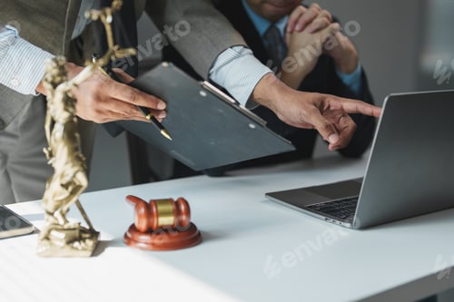 Preview: Lawyers discussing case using laptop and documents in office