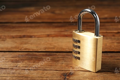 Preview: One steel combination padlock on wooden table, closeup. Space for text
