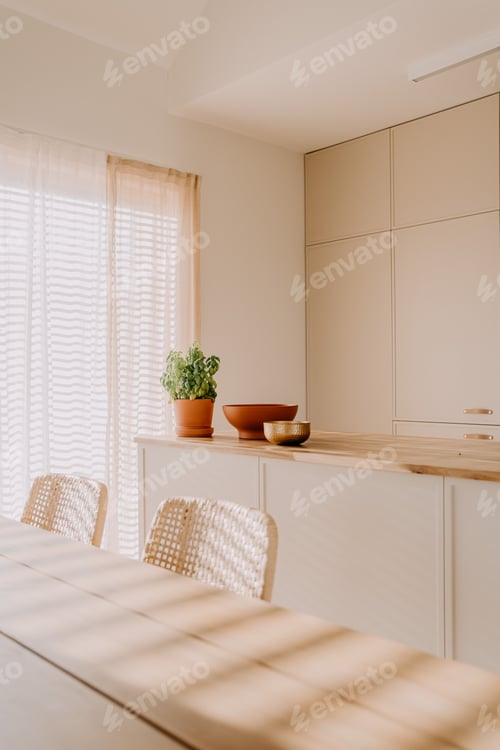 Preview: Modern dining room featuring light-colored furniture and a large window with blinds