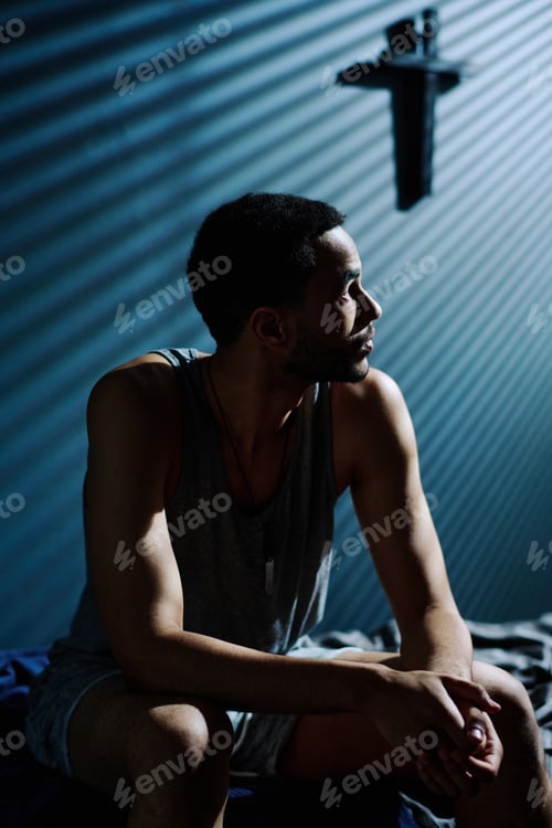 Preview: Young tired and unhappy man looking at moonlight coming through window