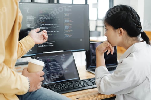 Preview: Team of young computer programmers cooperating while working on desktop PC in the office.
