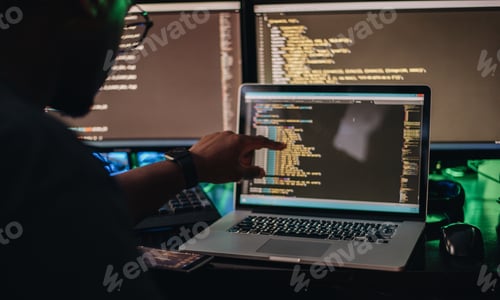 Preview: African American man sitting at computer desk looking at computer code, programming, developer