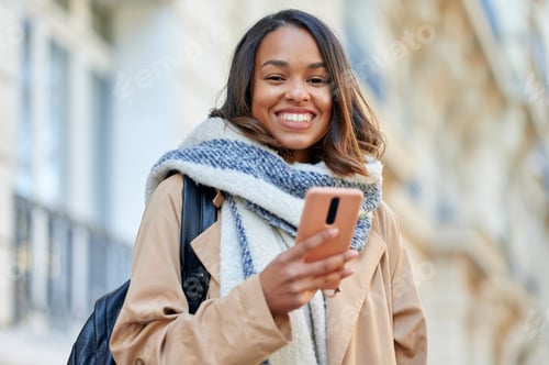 Preview: Portrait of woman with mobile phone in the street