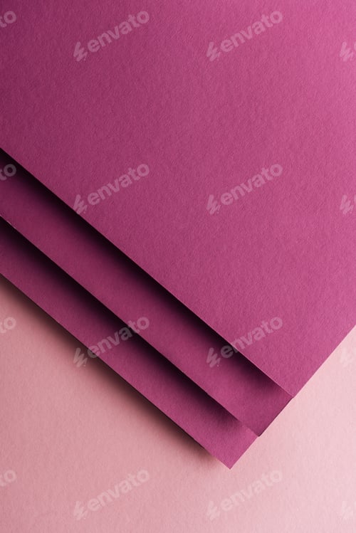 Preview: top view of blank and colorful burgundy sheets of paper on pink background with copy space