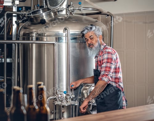 Preview: Old man dressed in apron working in modern brewery