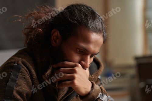 Preview: Thoughtful Long-Haired Man Contemplating Indoors