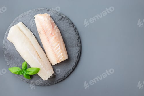 Preview: Fresh raw cod fillet with basil on stone plate, horizontal, copy