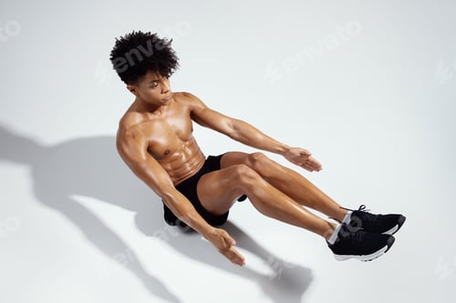 Preview: Fit Guy Exercising Sitting In Boat Yoga Pose In Studio