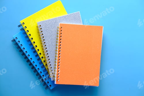 Preview: high angle view of color notepads on color background