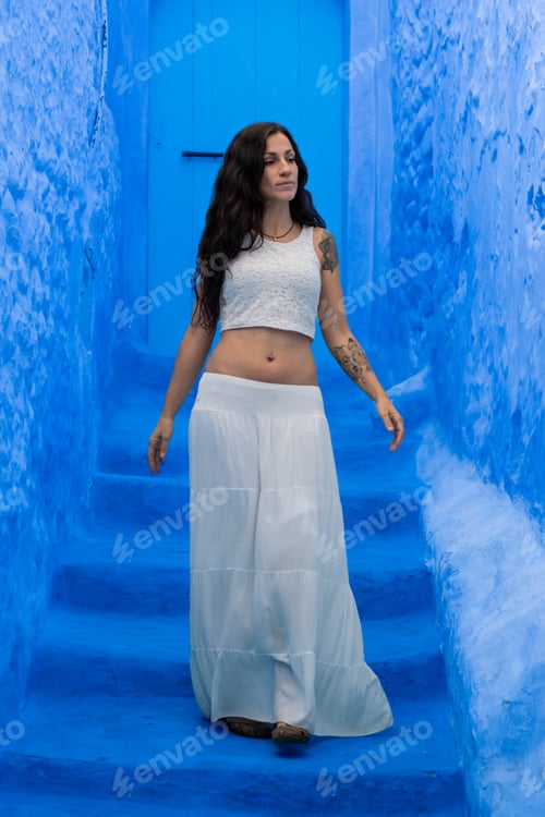 Preview: Young woman looking on blue wall