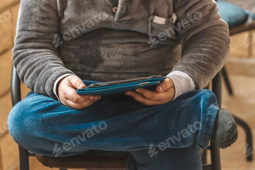 Preview: Child Sitting with a Tablet in Their Lap