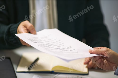 Preview: Caucasian Middle Aged Man Handing Business Document to Colleague during Meeting