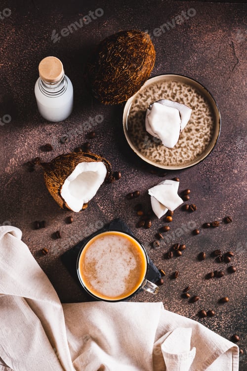 Preview: Cup of iced coconut coffee, coconut pulp and coffee beans on table top and vertical view