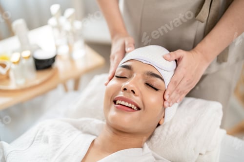 Preview: Beautiful woman getting head and facial massage treatment at beauty spa.