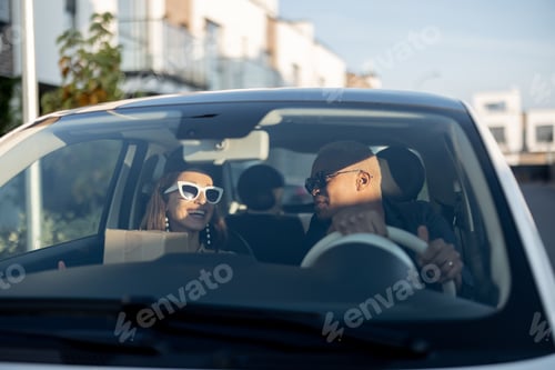 Preview: Multiracial couple riding in car at sunny day