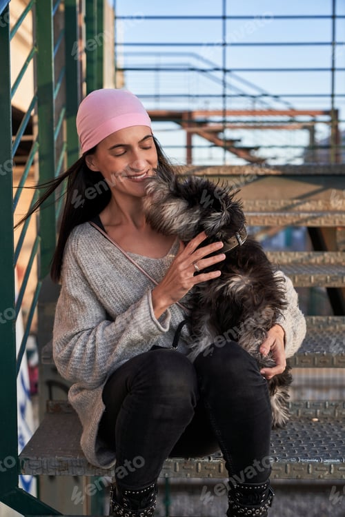 Vista previa: Contenido: Joven hispana acariciando a un perro esponjoso en las escaleras de St