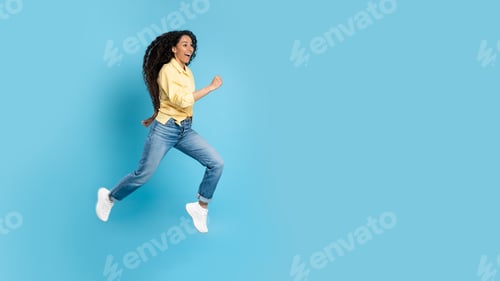 Preview: Cheerful Middle Eastern Woman Running In Mid Air, Blue Background