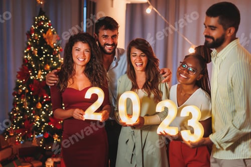 Visualização: Amigos segurando números iluminativos de 2023 representando o próximo Ano Novo