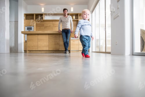 Preview: Father watching male toddlers walking on dining room floor