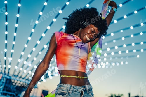 Preview: Young woman dancing and enjoying music at summer festival