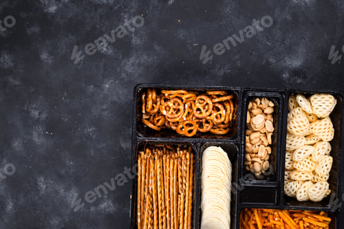 Preview: a variety of snacks on the box for beer on a concrete black table