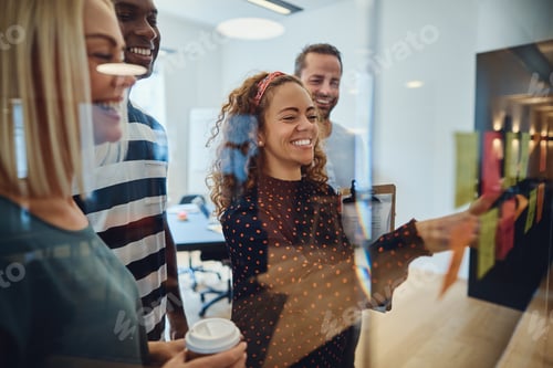 Preview: Smiling designers brainstorming together with notes in an office