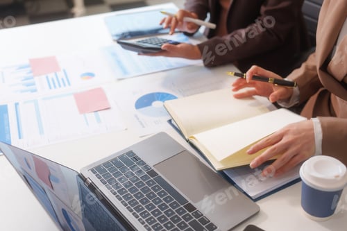 Preview: Close-up of two businesswomen working at desk discussing business strategies, analyzing financial