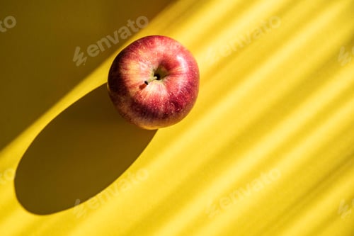 Preview: Red apple on yellow background top view